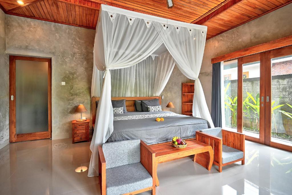 a bedroom with a bed with a canopy at Gami Ubud Villa in Ubud