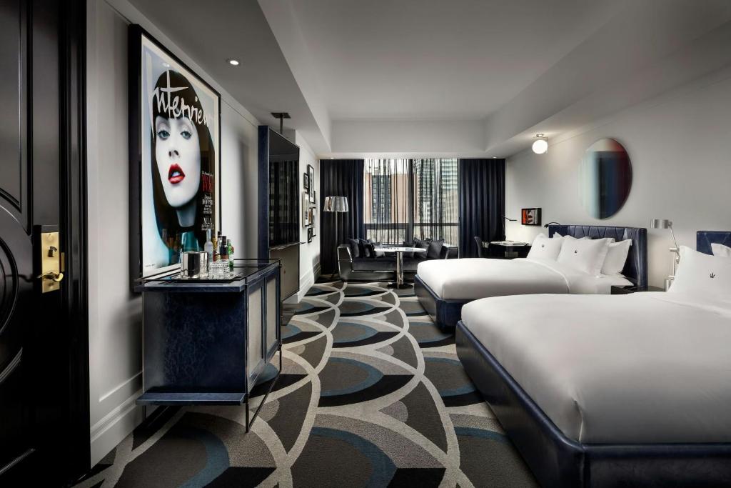 a hotel room with two beds and a sitting area at BISHA, a Luxury Collection Hotel, Toronto in Toronto