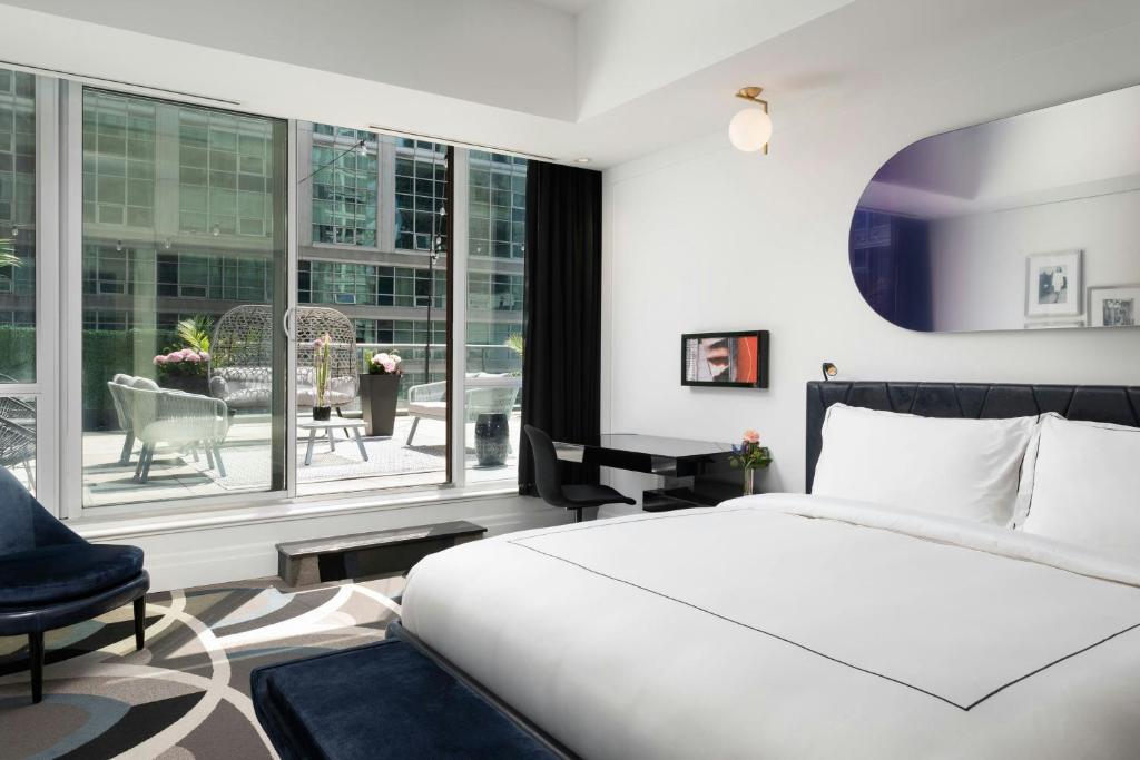 a bedroom with a bed and a large window at BISHA, a Luxury Collection Hotel, Toronto in Toronto