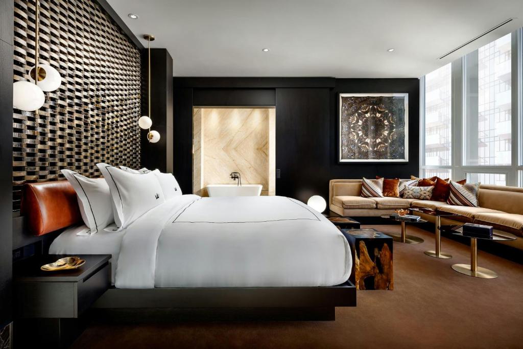 a bedroom with a large white bed and a couch at BISHA, a Luxury Collection Hotel, Toronto in Toronto