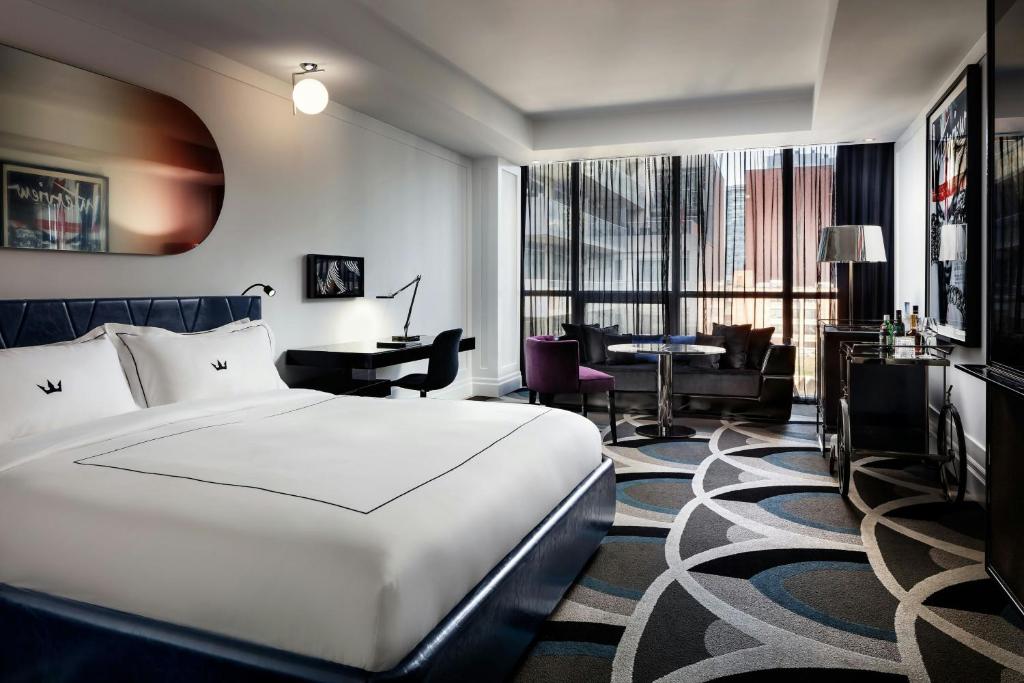 a hotel room with a large bed and a desk at BISHA, a Luxury Collection Hotel, Toronto in Toronto
