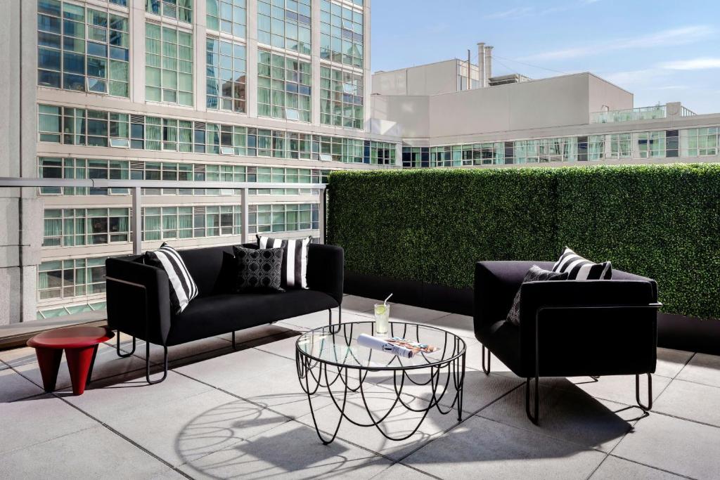 a patio with two couches and a glass table at BISHA, a Luxury Collection Hotel, Toronto in Toronto