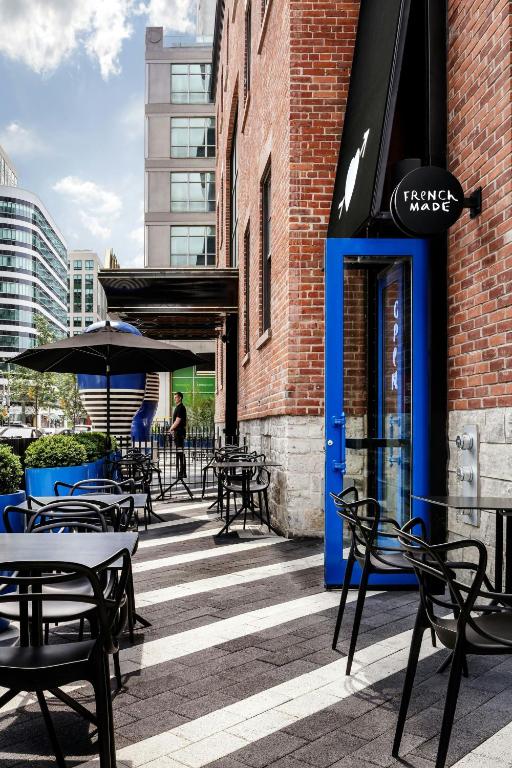 a patio with tables and chairs outside of a building at BISHA, a Luxury Collection Hotel, Toronto in Toronto
