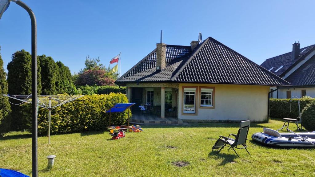 a small house with a yard with a lot of equipment at Domek Malina in Nadole