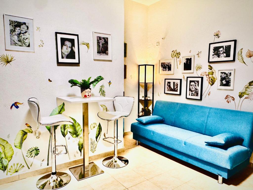 Appartamento Don Bosco في سوفيراتو مارينا: غرفة معيشة بها أريكة زرقاء وبعض النباتات