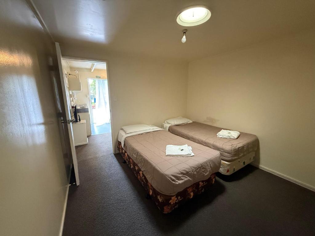 Postel nebo postele na pokoji v ubytování Camellia Court Family Motel