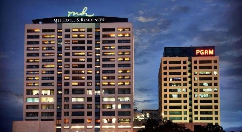a tall building with a sign on top of it at Richone Maluri Private Hotel in Kuala Lumpur