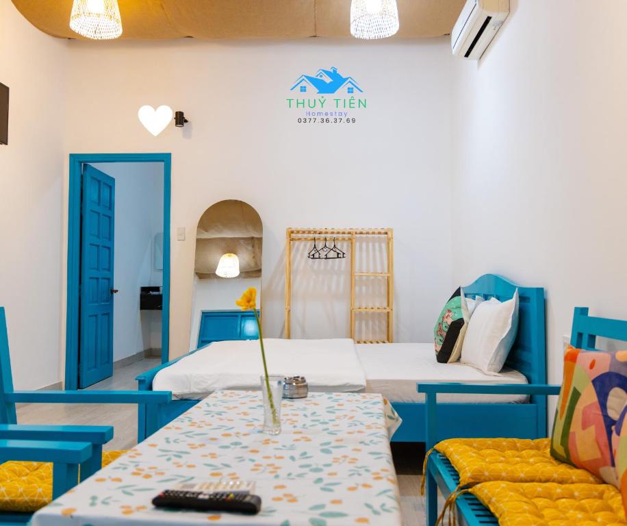 a room with two beds and a table and chairs at Thuy Tien Mui Ne Homestay BBQ Free in Mui Ne