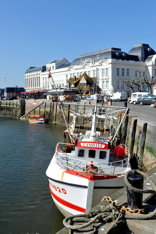 un bateau est amarré dans l'eau d'un port dans l'établissement Appartement Trouville proche plage, à Trouville-sur-Mer
