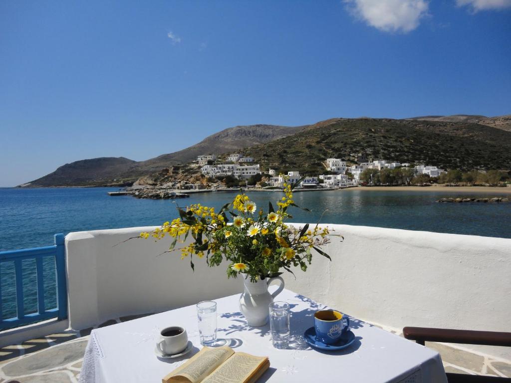 a table with a vase of flowers on top of the water at Ostria Studios - Spilia in Sikinos