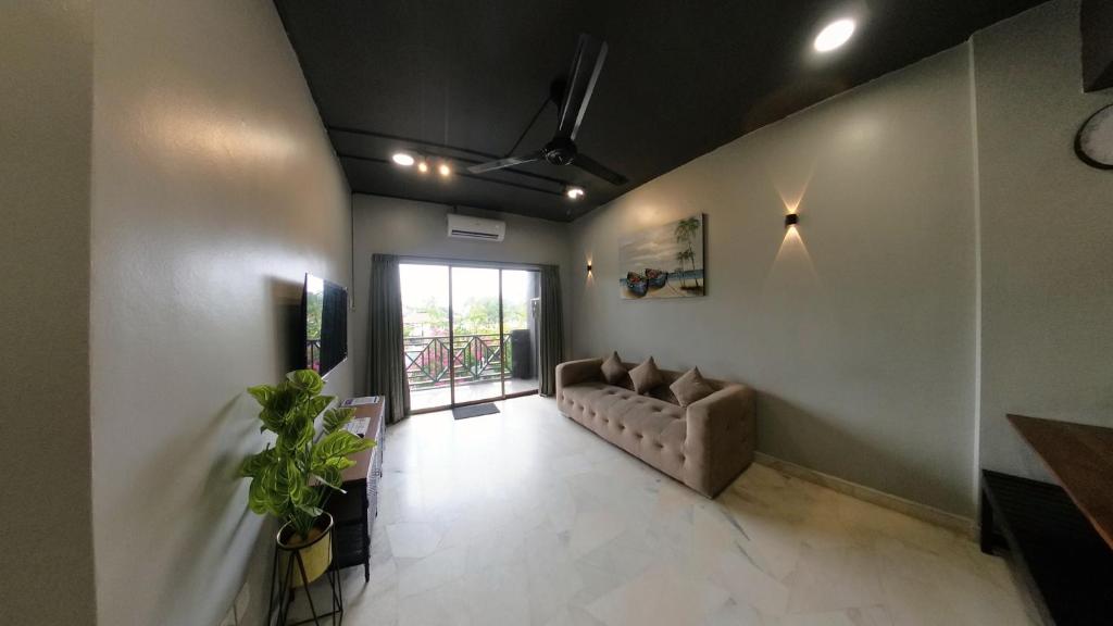 a living room with a couch and a window at 1-10pax DoorStep private beach & swimming pool in Port Dickson