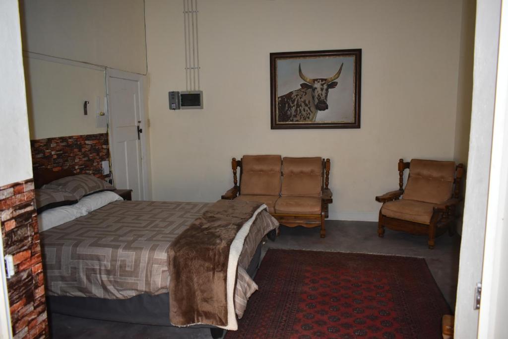 Un dormitorio con una cama y dos sillas. en Hantam Kunskamer, en Calvinia