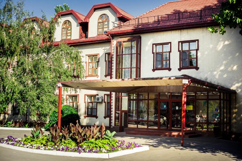 um grande edifício branco com um telhado vermelho em Assol Hotel em Taganrog