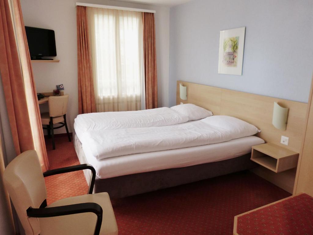 Postel nebo postele na pokoji v ubytování Hotel Rigi Vitznau