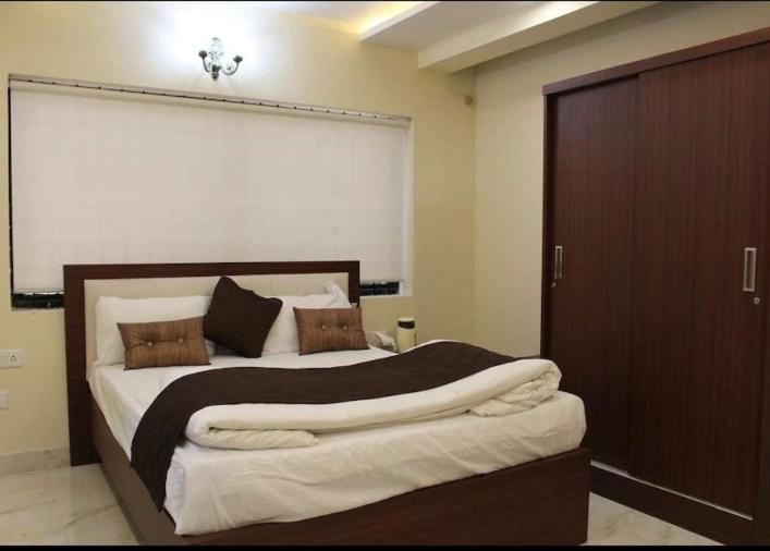 a bedroom with a large bed with a brown door at Family Friendly Guest House in Bengaluru