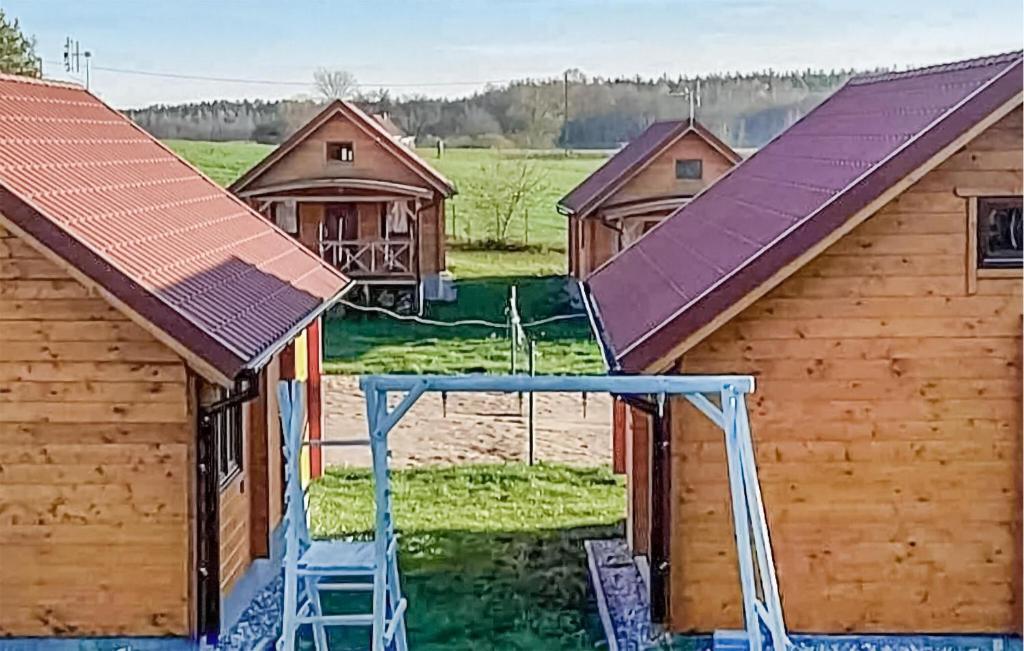a group of wooden buildings with purple roofs at Gorgeous Home In Rybical With Kitchen in Ryn