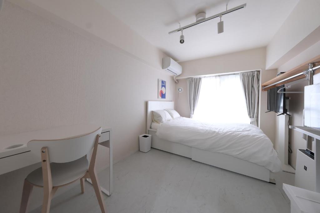 a bedroom with a bed and a chair and a window at 5mins walk to Kameari Station within 30mins to Ginza, Asakusa, Skytree Direct bus to Haneda Airport & Tokyo Disneyland departing from Kameari Station in Tokyo