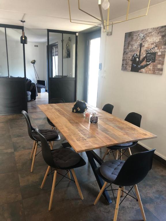 - une table et des chaises en bois dans l'établissement Charmante maison au cœur des vignes, à Paris-lʼHôpital