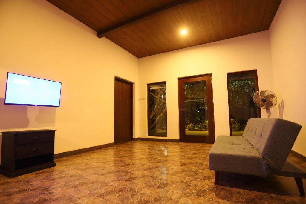 a living room with a couch and a flat screen tv at AMcroos in Negombo