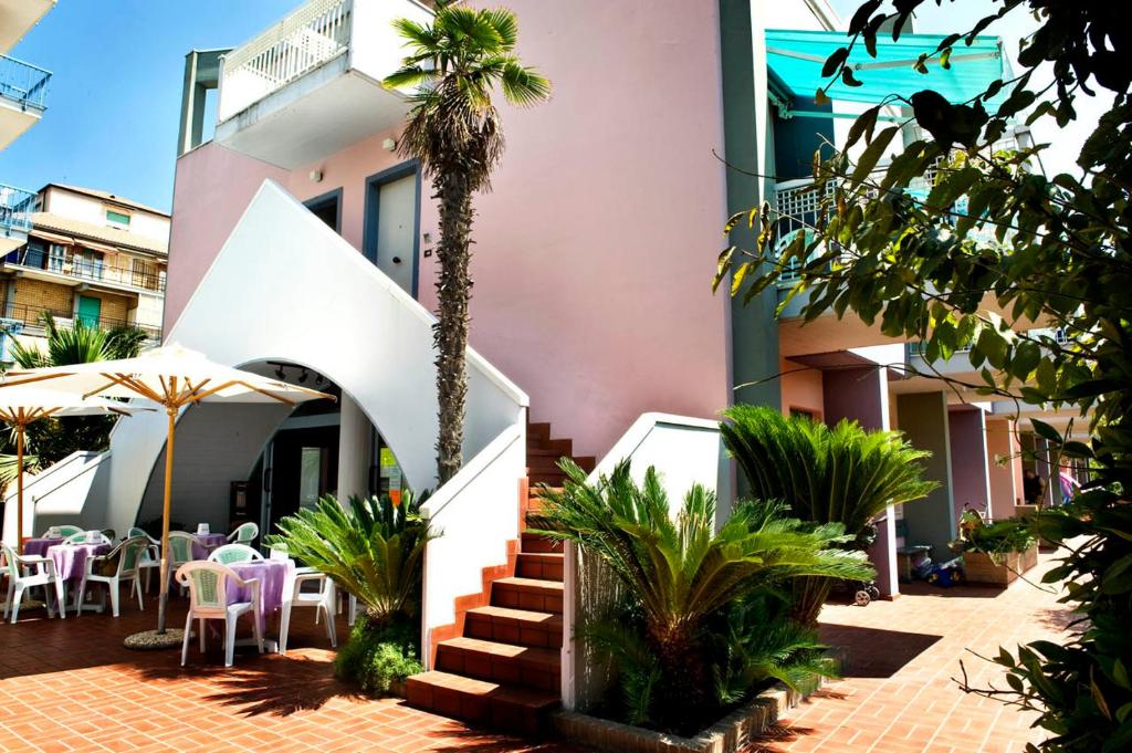 a building with a palm tree in front of it at Residence Mediterraneo in San Benedetto del Tronto