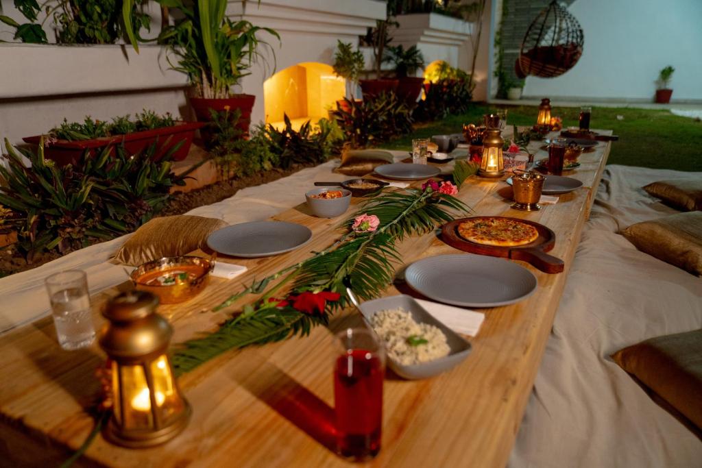 a long wooden table with plates and food on it at The Palace Inn - A boutique villa in Jaipur