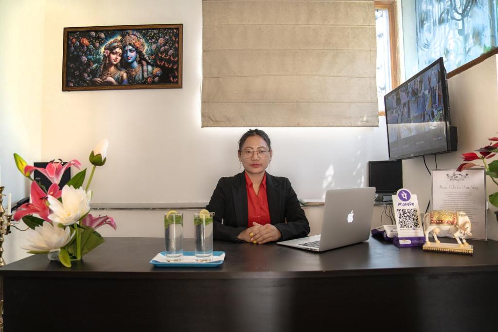 a woman sitting at a desk with a laptop computer at The Palace Inn - A boutique villa in Jaipur