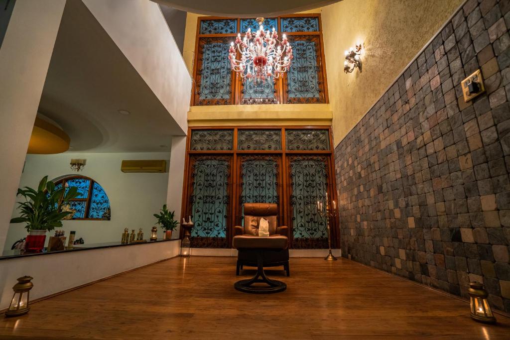 a living room with a chair and a chandelier at The Palace Inn - A boutique villa in Jaipur