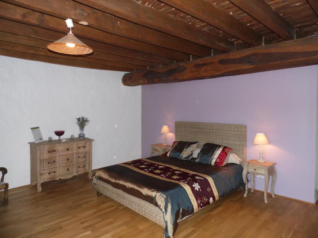 a bedroom with a large bed and a wooden ceiling at Chambre d hôtes Domaine Des Patrus in LʼÉpine-aux-Bois