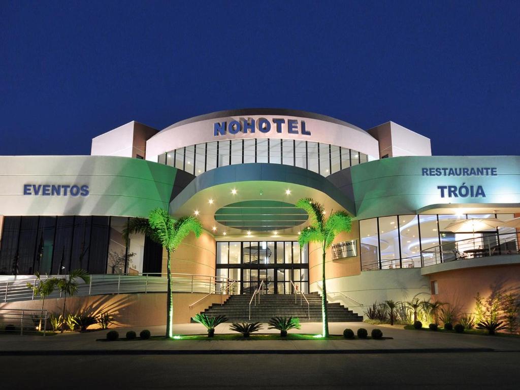 a large building with stairs in front of it at night at Nohotel Premium Americana in Americana