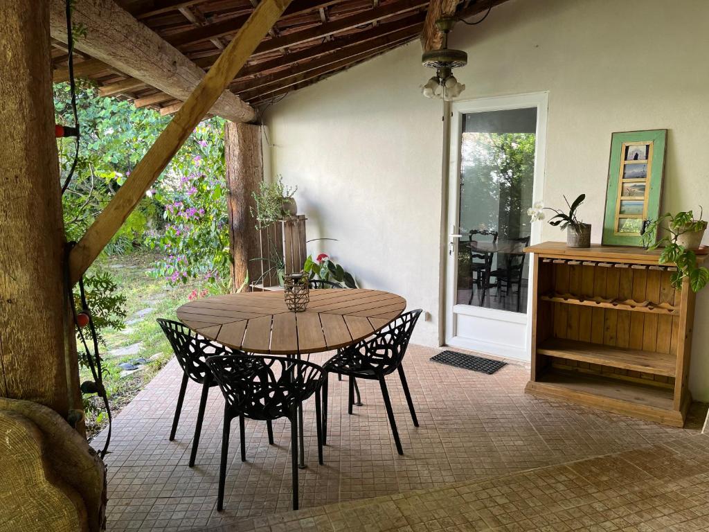 une table et des chaises en bois sur une terrasse dans l'établissement Charmante petite maison avec terrasse et jardin, proche tram, à Castelnau-le-Lez