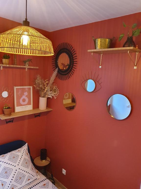 - une chambre avec des murs rouges, des miroirs et une lampe dans l'établissement studio cosy idéalement situé parking privé, à Ajaccio