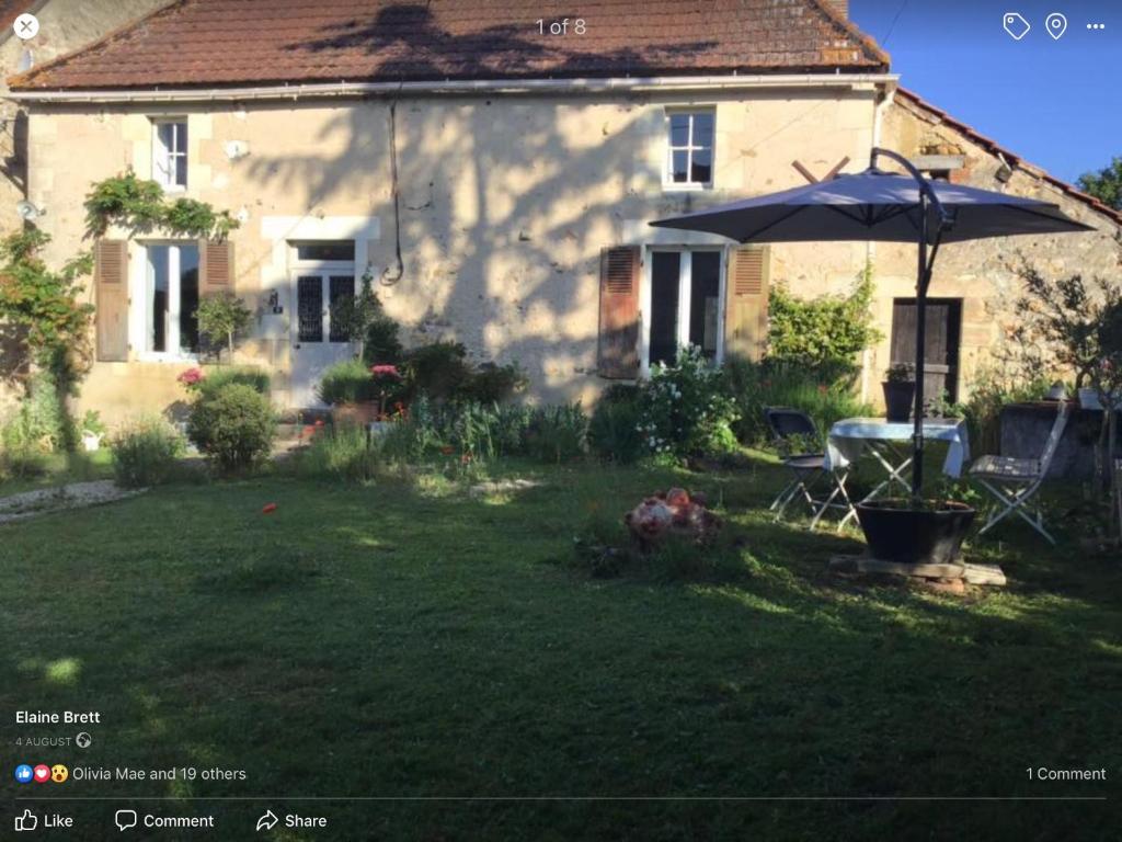 una casa con un paraguas en el patio en Le Domaine, en Lignac