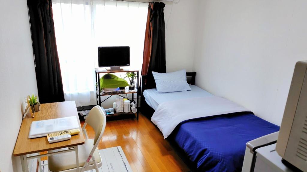 秦野市にあるKokusaigakusya Ozukikaikan - Vacation STAY 17718のベッドが2つと机とコンピューターがある部屋