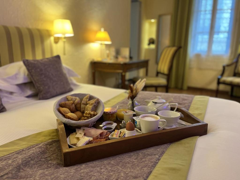 a tray of food on top of a bed at Hotel d'Aragon - Place de la Comédie in Montpellier