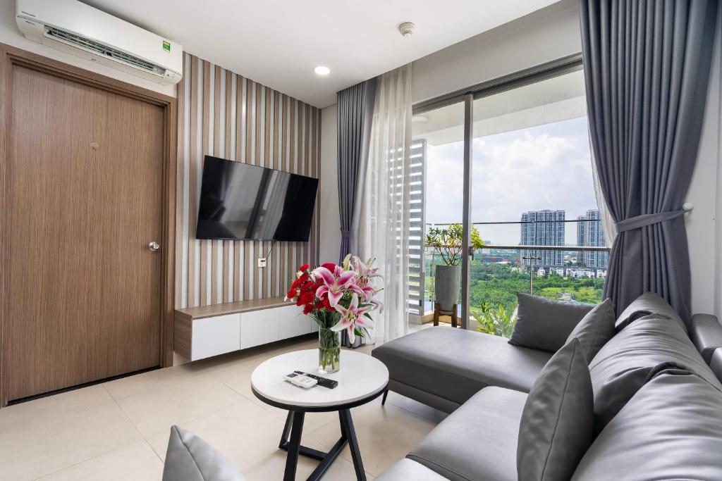 a living room with a couch and a tv at Swimming Pool 35th Floor District 7 in Ho Chi Minh City