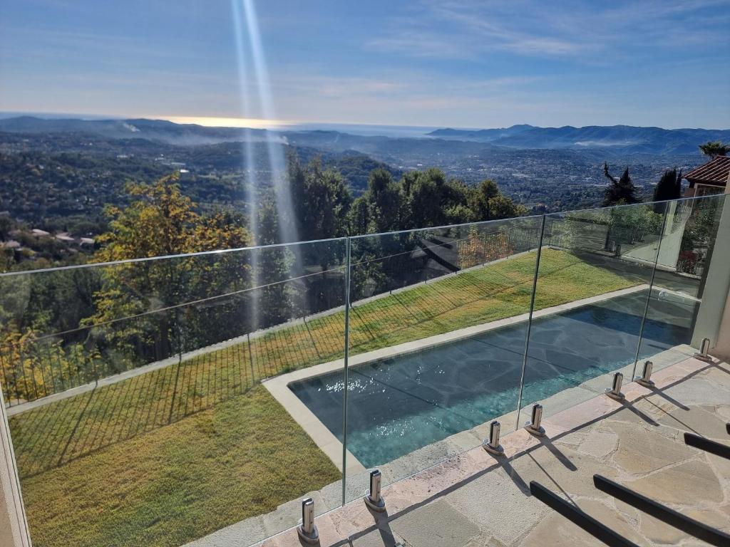 une maison avec un balcon en verre et une piscine dans l'établissement Villa Horizon, à Grasse