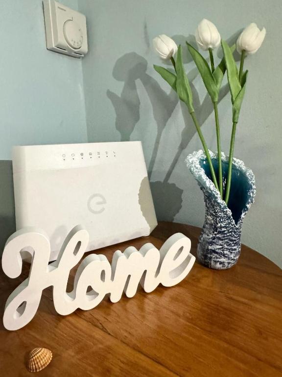 a table with a vase with flowers and a box at MarePorto House in Fiumicino