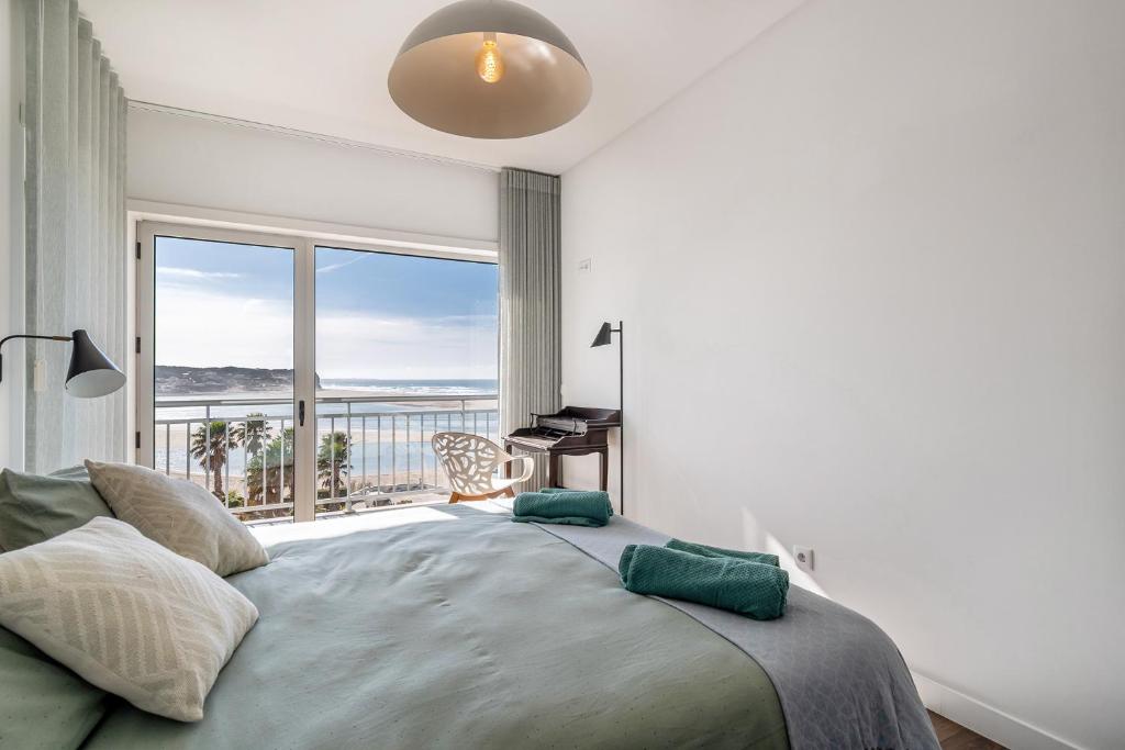 a bedroom with a large bed with a large window at FozPenthouse in Foz do Arelho