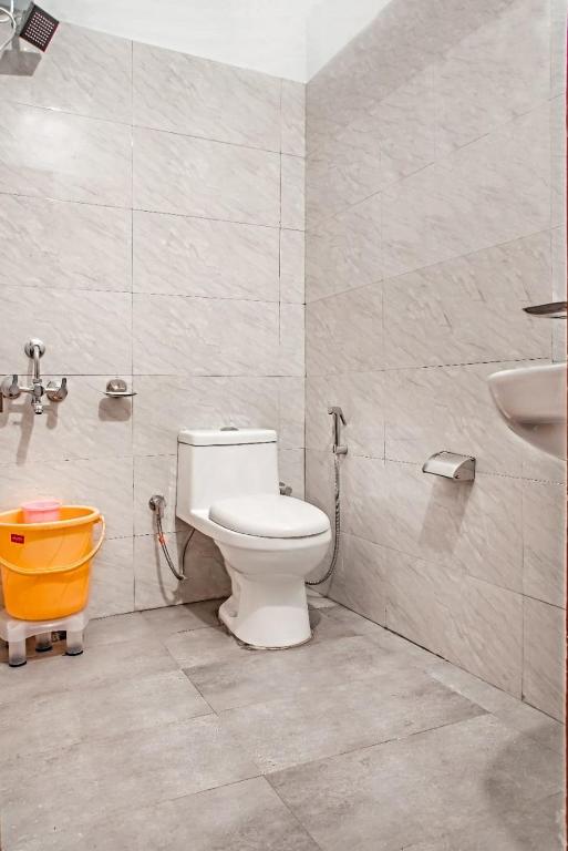 a bathroom with a toilet and a sink and a bucket at Apts Kasauli in Kasauli