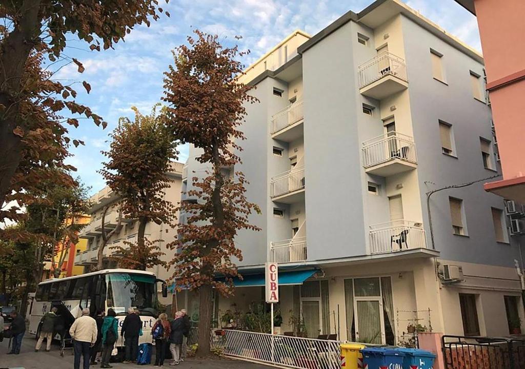 un bus est garé devant un bâtiment dans l'établissement HOTEL CUBA nuova gestione, à Rimini