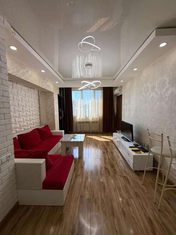 a living room with a red couch and a tv at Apartment in Tumanyan street in Yerevan
