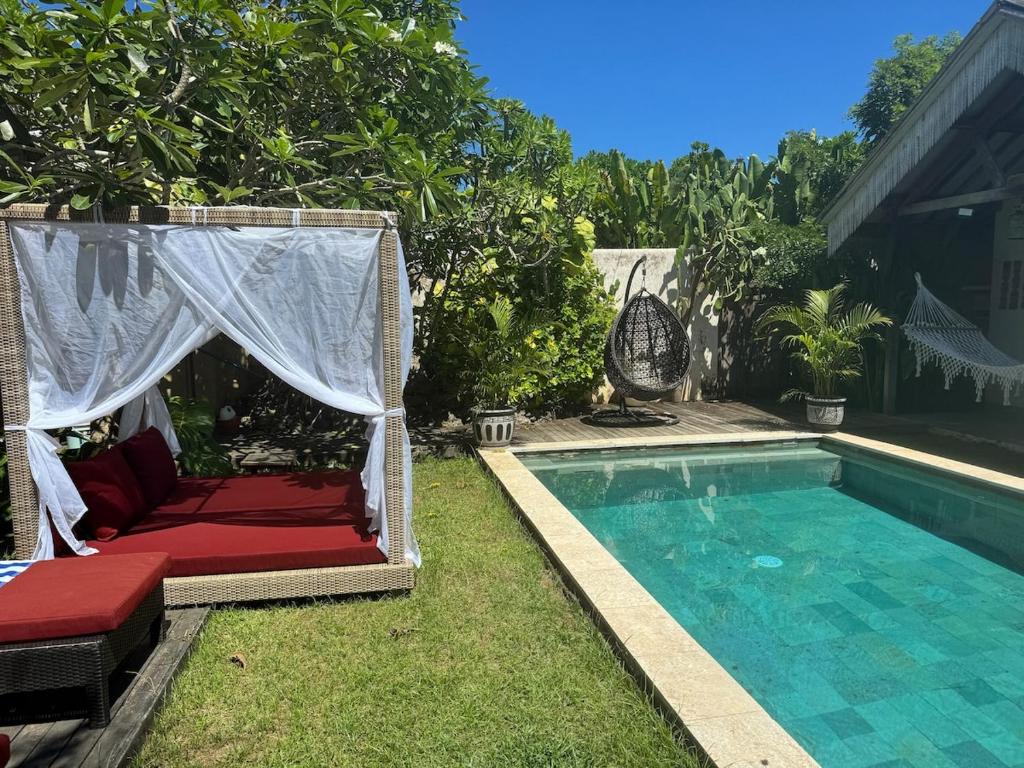 una piscina con gazebo e un letto accanto a una piscina di Beautiful Rustic 3bd Villa in Bingin a Uluwatu