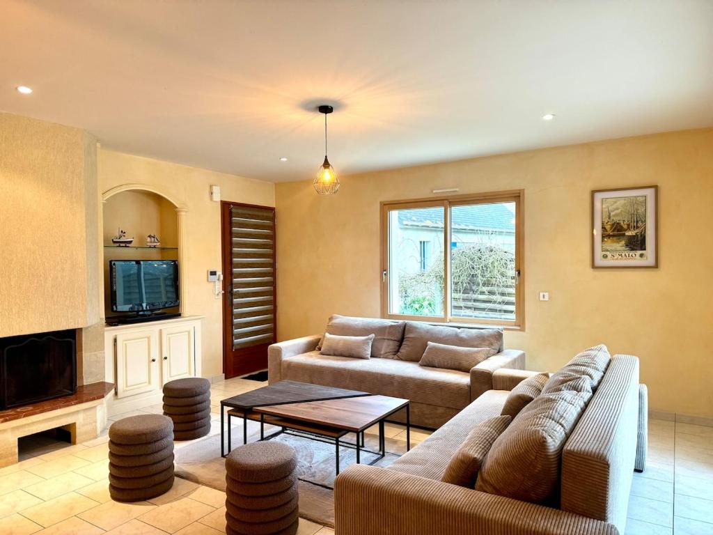 a living room with a couch and a table at Jolie maison - 15 Mins des plages in Pleslin-Trigavou