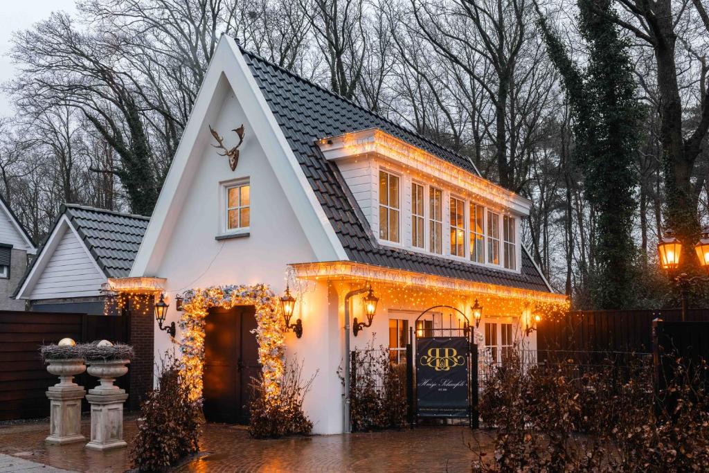 a white house with christmas lights on it at B&B Huisje Schaufeli in Apeldoorn