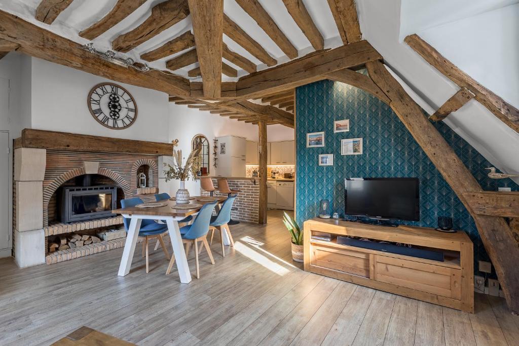 - un salon avec une table à manger et une cheminée dans l'établissement La Goélette - Entre Port & Plage - Cosy, à Dieppe