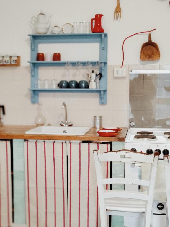 - une cuisine avec des étagères bleues, un évier et une cuisinière dans l'établissement Casa nel borgo, à Domaso