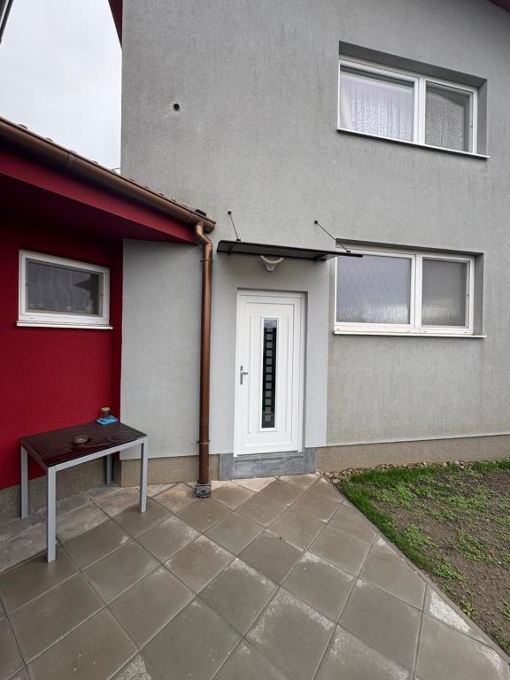 a house with a white door and a table next to it at apartman pri X Bionic Sphere Samorin 6 km od Casino Card Hotel in Blatná na Ostrove
