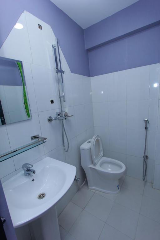 un bagno bianco con lavandino e WC di Paila Hostel Lakeside a Pokhara