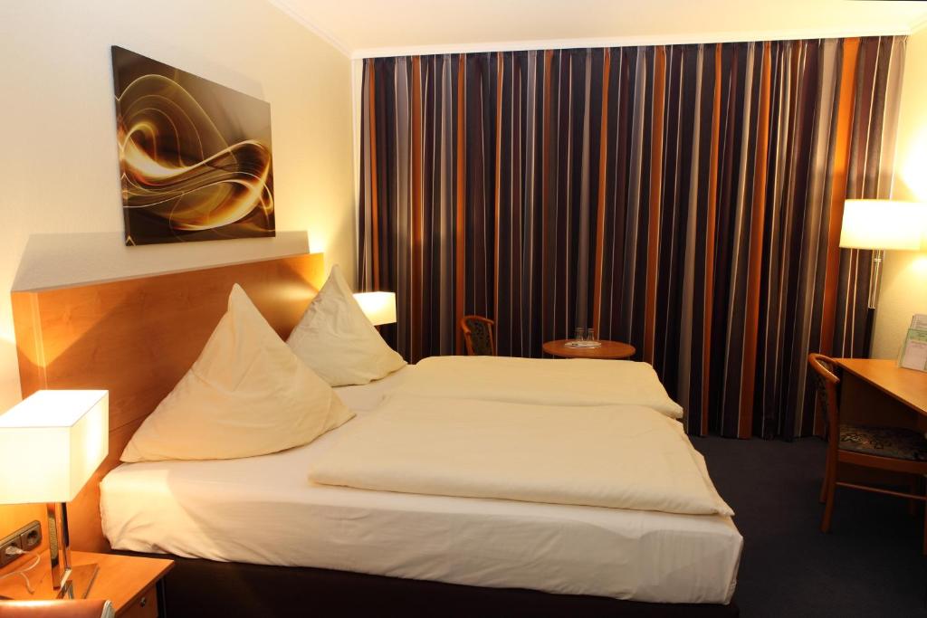 ein Hotelzimmer mit einem großen weißen Bett. in der Unterkunft Hotel Boulevard - Superior in Köln
