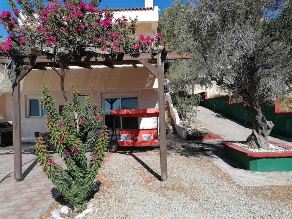 a pergola with flowers on it in front of a house at Villa Klelia in Afantou